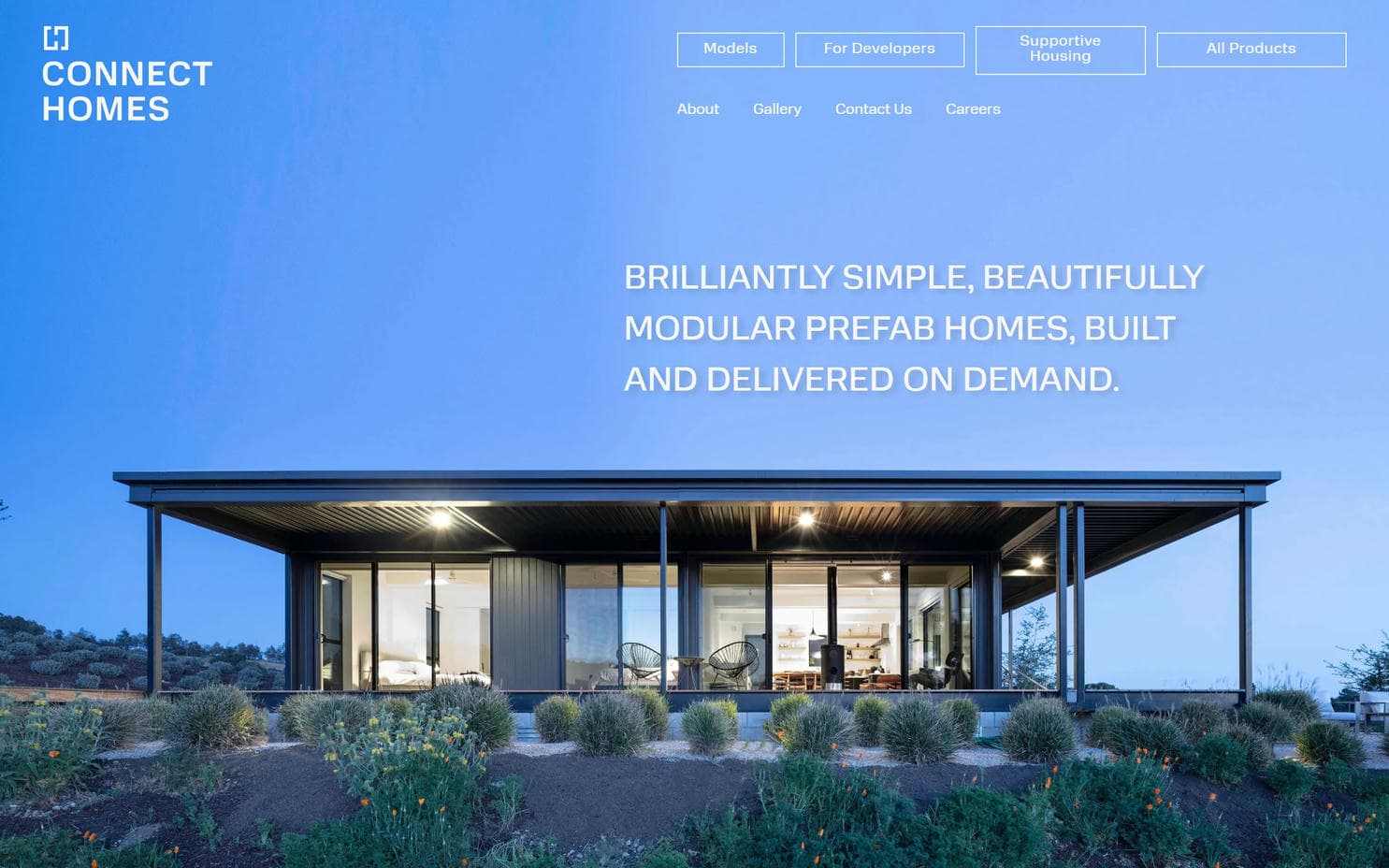 A modern home with a flat roof and desert xeriscaping from Connect Homes's construction company website