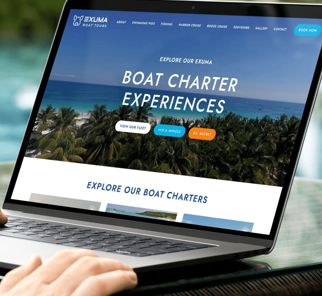 A person's hands are visible as they use a laptop displaying the "EXUMA BOAT TOURS" website.